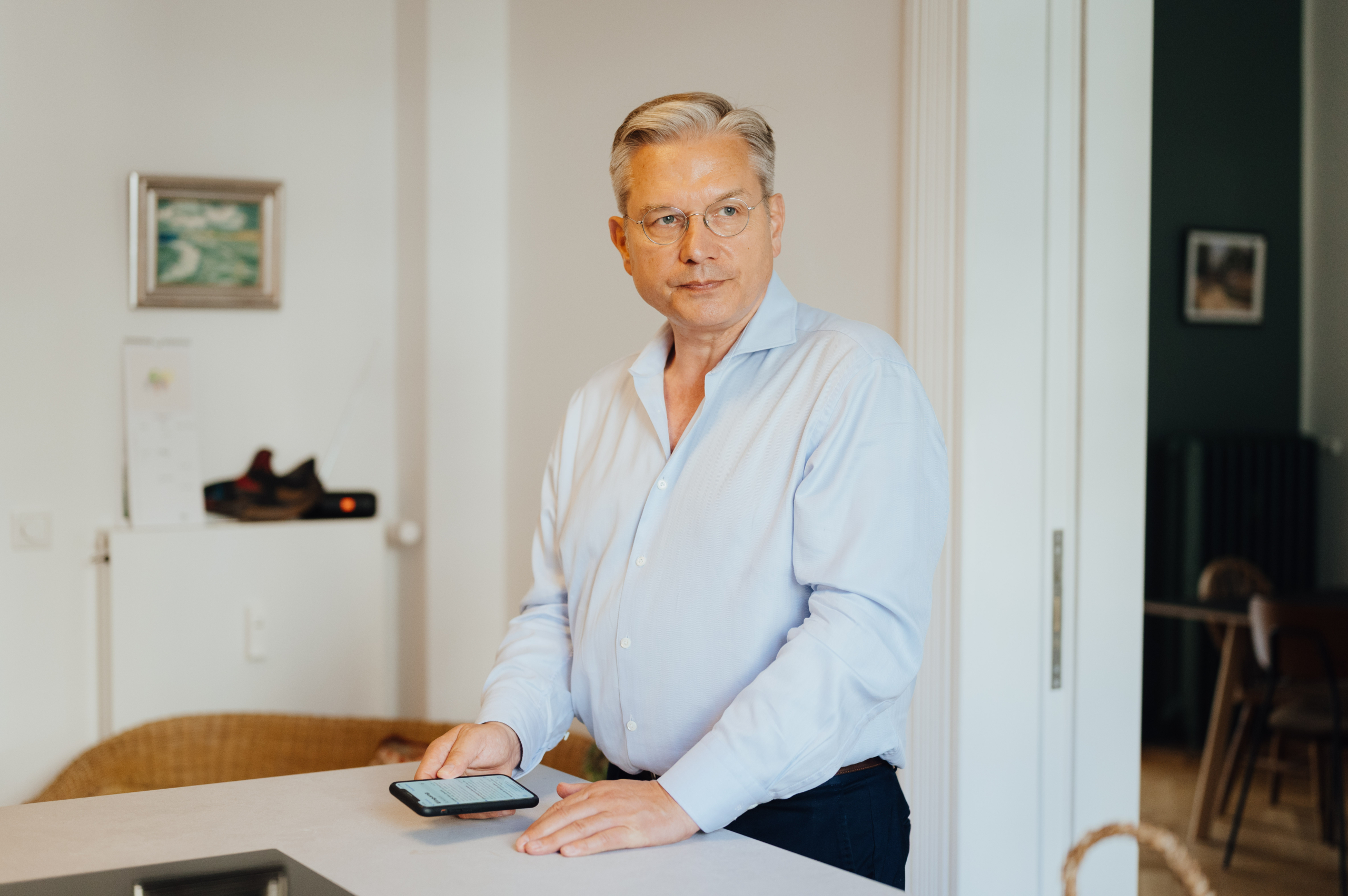 Ulrich Weinkath steht in einem Interior-Showroom am Neuen Wall. Er begutachtet eine Stehlampe mit kreisrunden Lampenschirmen aus Glas.